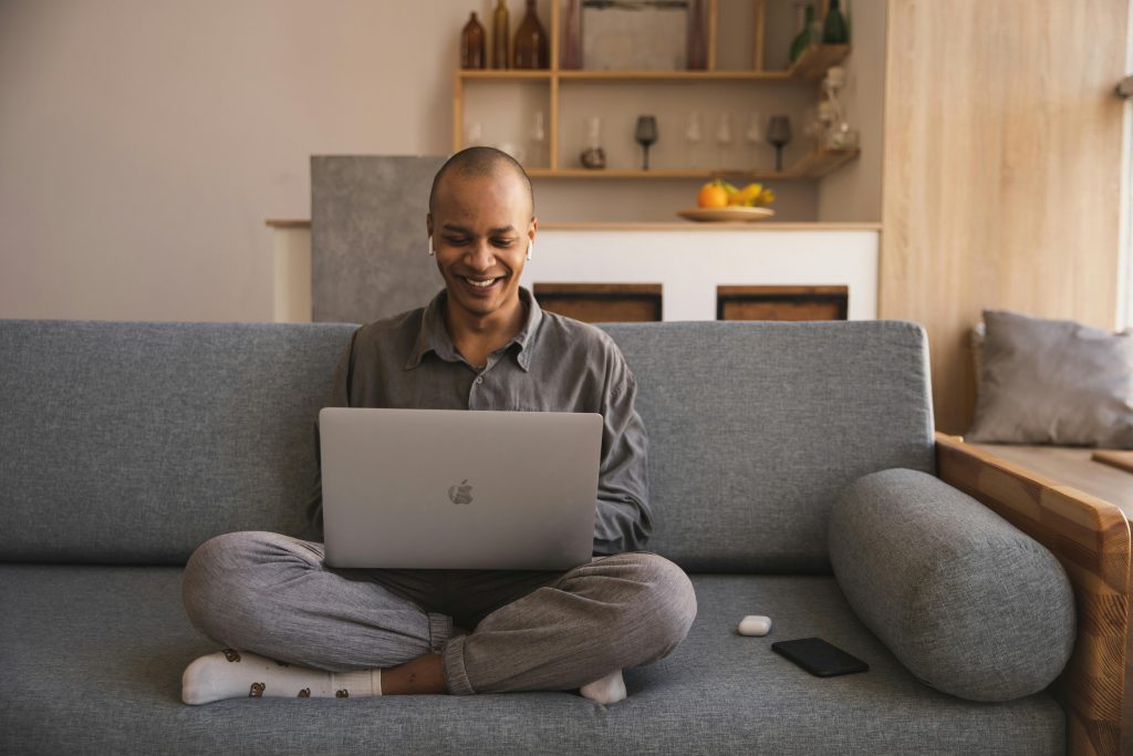 man sitting comfortably on a couch with his laptop, working at home